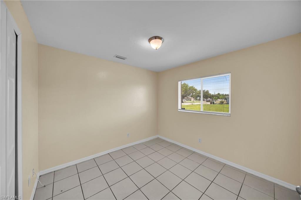 Interior room featuring neutral wall paint, square tile flooring, and a single window