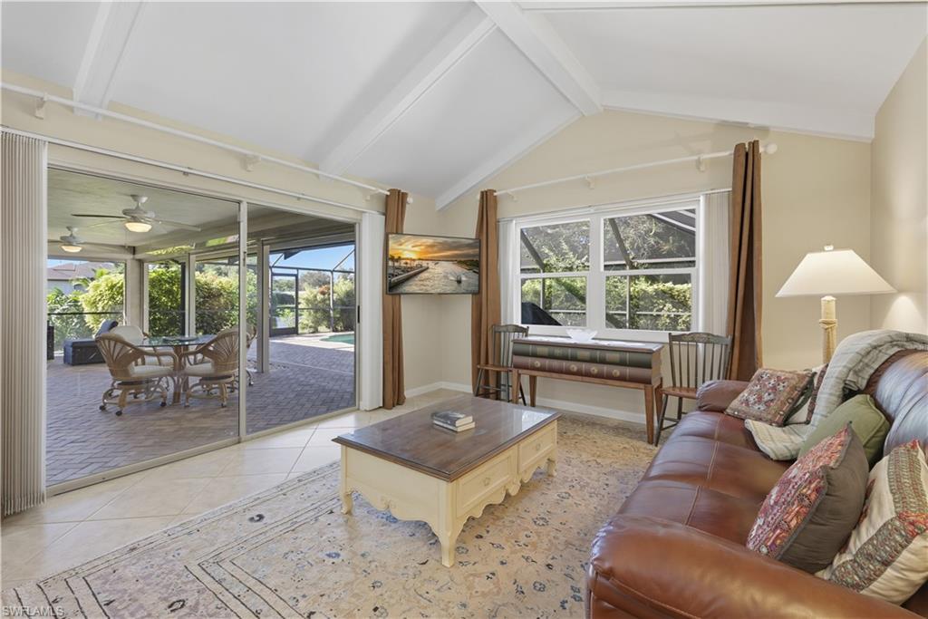 Tiled living area featuring a sunroom and a ceiling fan