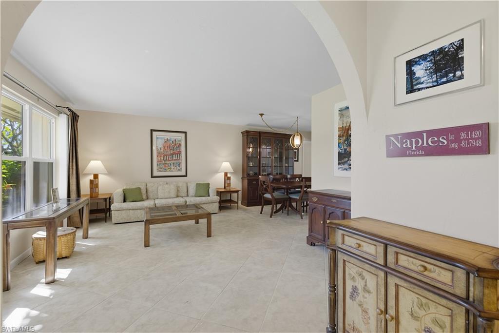 Living area with arched walkways and light tile patterned flooring