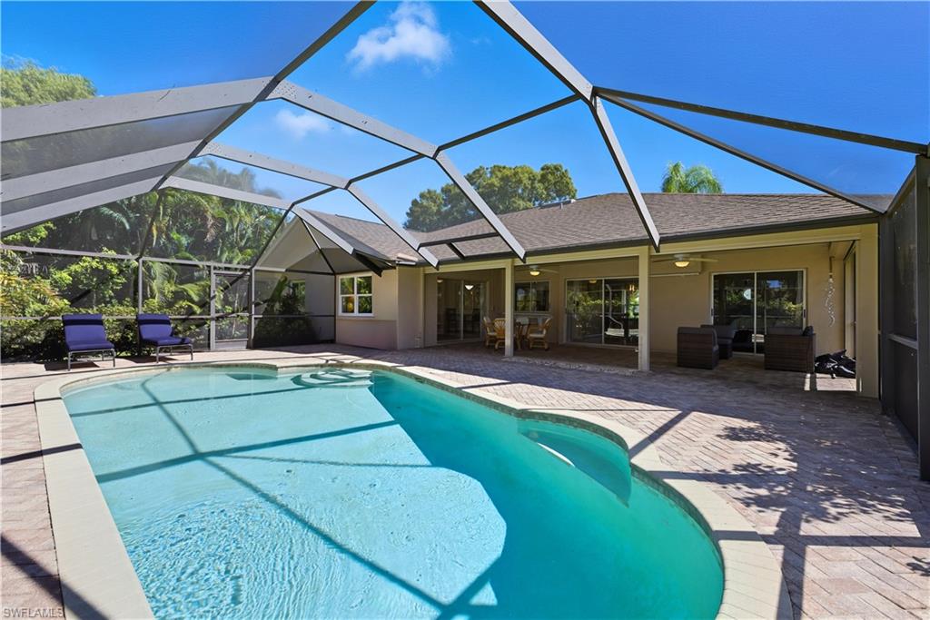 Swimming pool featuring a sunroom, glass enclosure, a patio area, a ceiling fan, and outdoor lounge area