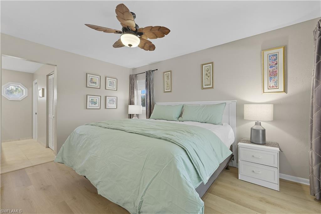 Bedroom featuring light wood-style flooring, a ceiling fan, and multiple windows