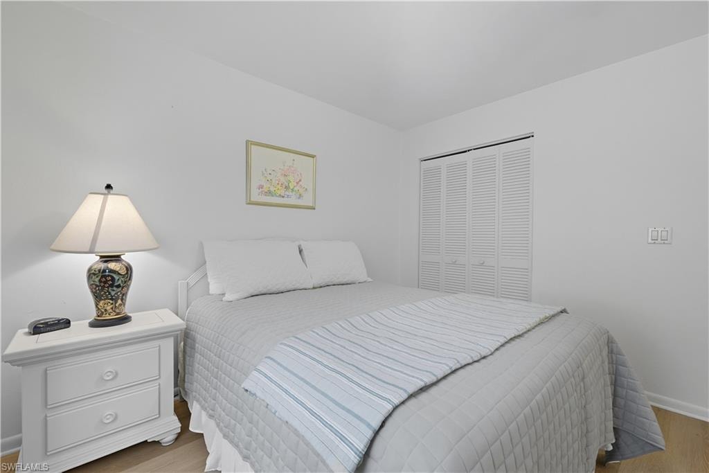 Bedroom with wood finished floors and a closet
