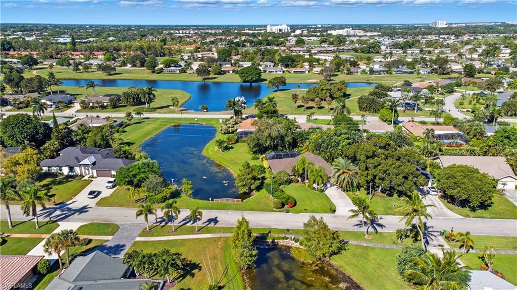 Aerial view of property and surrounding area with a nearby body of water and nearby suburban area