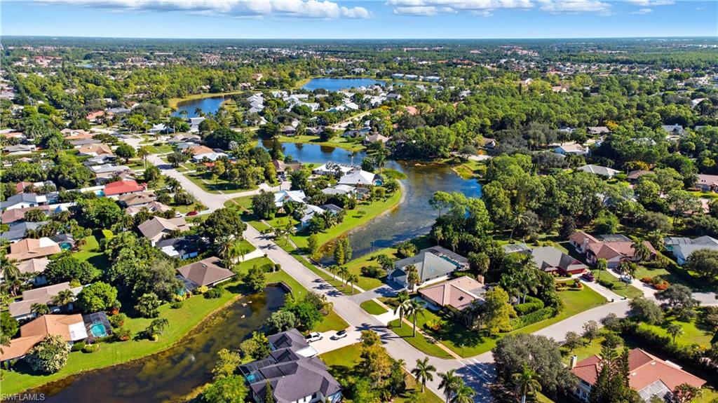 Aerial view of property and surrounding area featuring nearby suburban area and a nearby body of water
