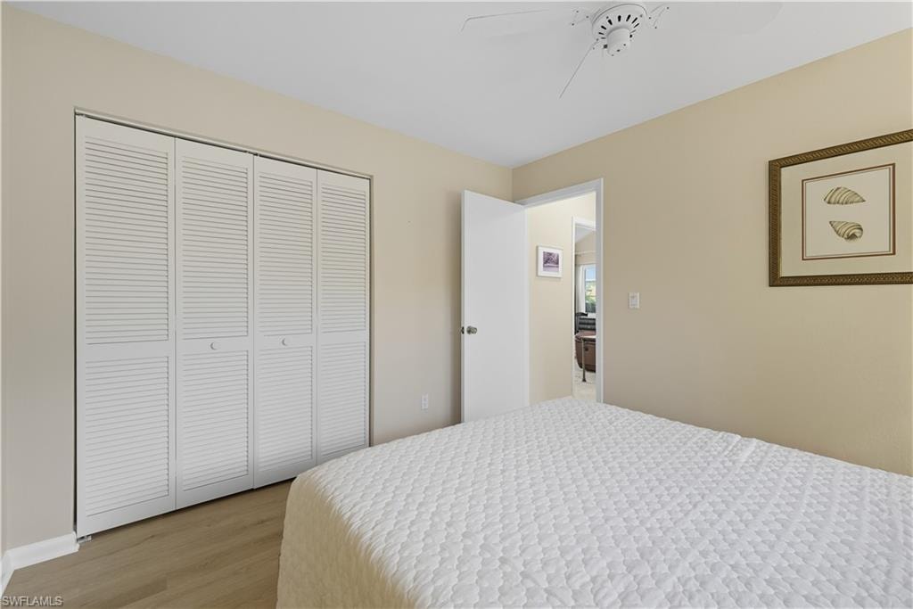 Bedroom with wood finished floors, a closet, and a ceiling fan