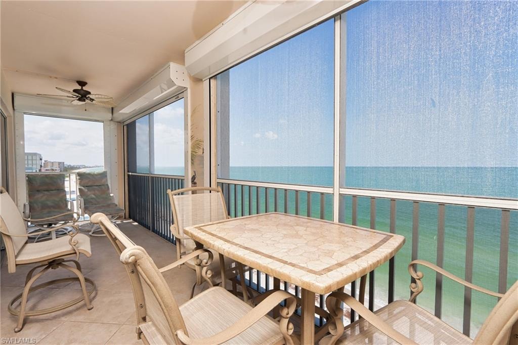 Sunroom featuring ceiling fan and a water view