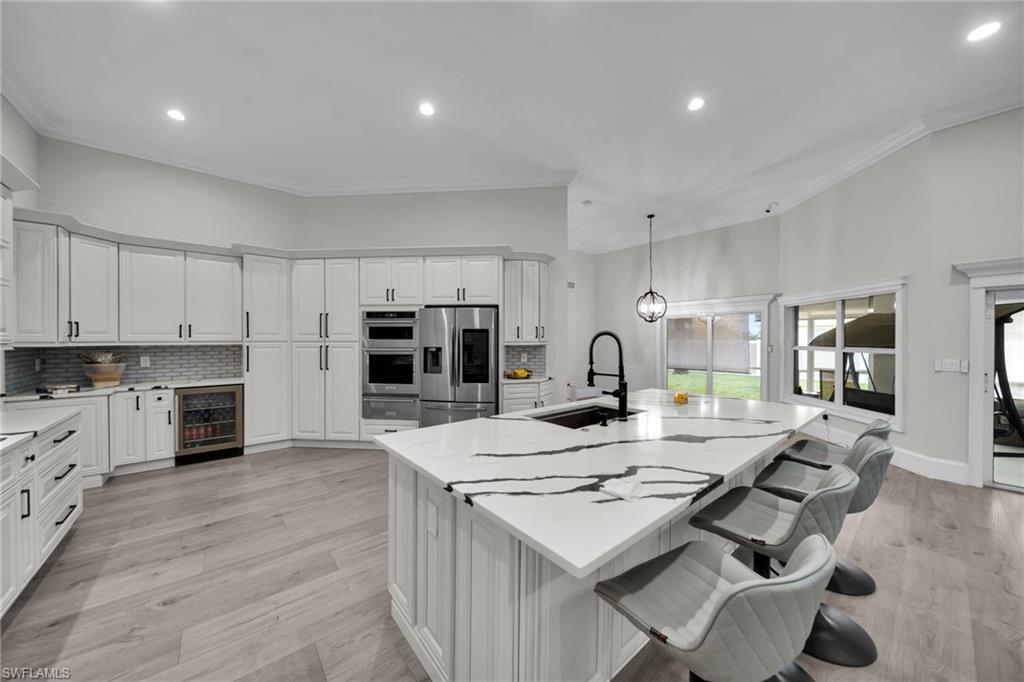Spacious kitchen featuring a large island with a patterned countertop and undermount sink