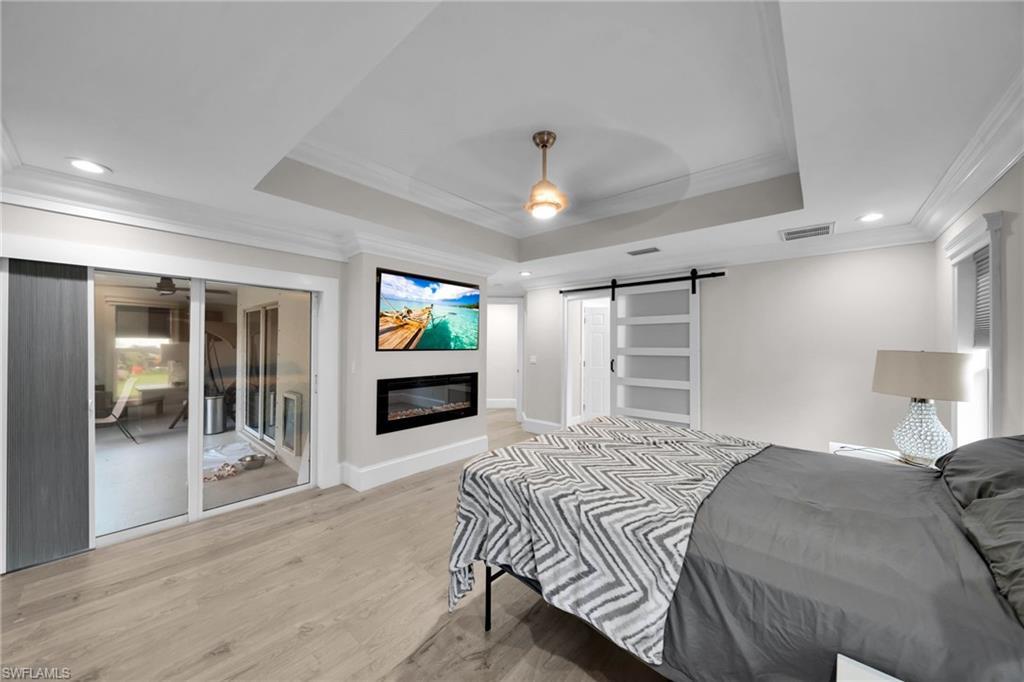 Recessed wall-mounted television above an electric fireplace, set against light-toned walls