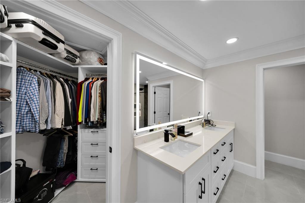 Dual sink vanity featuring white cabinetry, light-toned countertops, and matte black fixtures