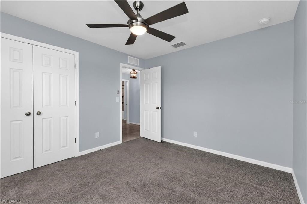Room featuring plush gray carpeting, light blue wall paint, and white baseboards