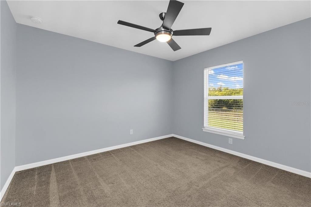 Carpeted room featuring a ceiling fan with integrated lighting, a single window with horizontal blinds, and light-toned wall paint