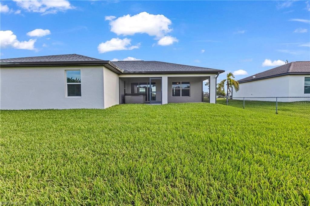 Expansive green lawn with a screened patio, ideal for outdoor relaxation