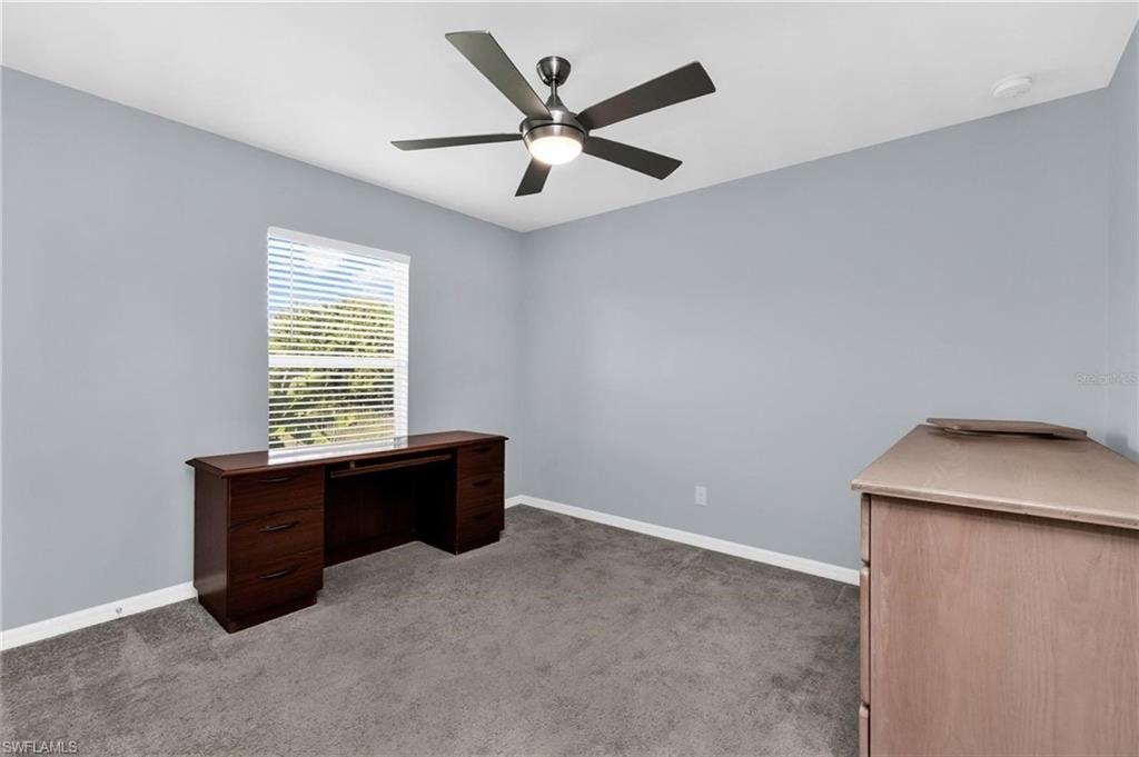 Spacious room with light gray walls, gray carpeting, and a ceiling fan with integrated lighting