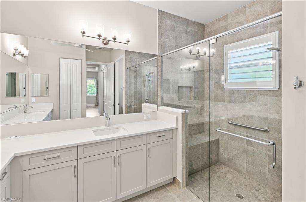 Primary Bathroom Spacious bathroom featuring a dual vanity with white countertops, light gray cabinetry, and undermount sinks