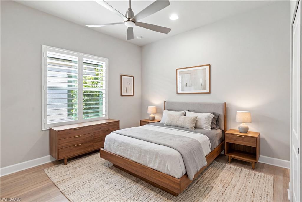 Guest Room 2 Room Digitally Staged  Bedroom featuring wood-finish flooring, a ceiling fan with integrated lighting, recessed lighting, and a window with white plantation shutters