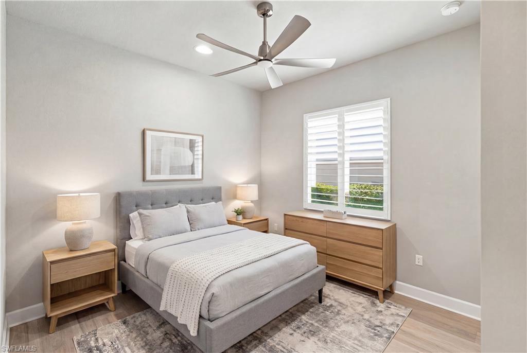 Room Digitally Staged Guest Room Light-filled room featuring a ceiling fan with integrated lighting, recessed lighting, and a window with plantation shutters