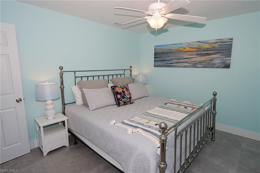 Bedroom featuring dark tile flooring and ceiling fan