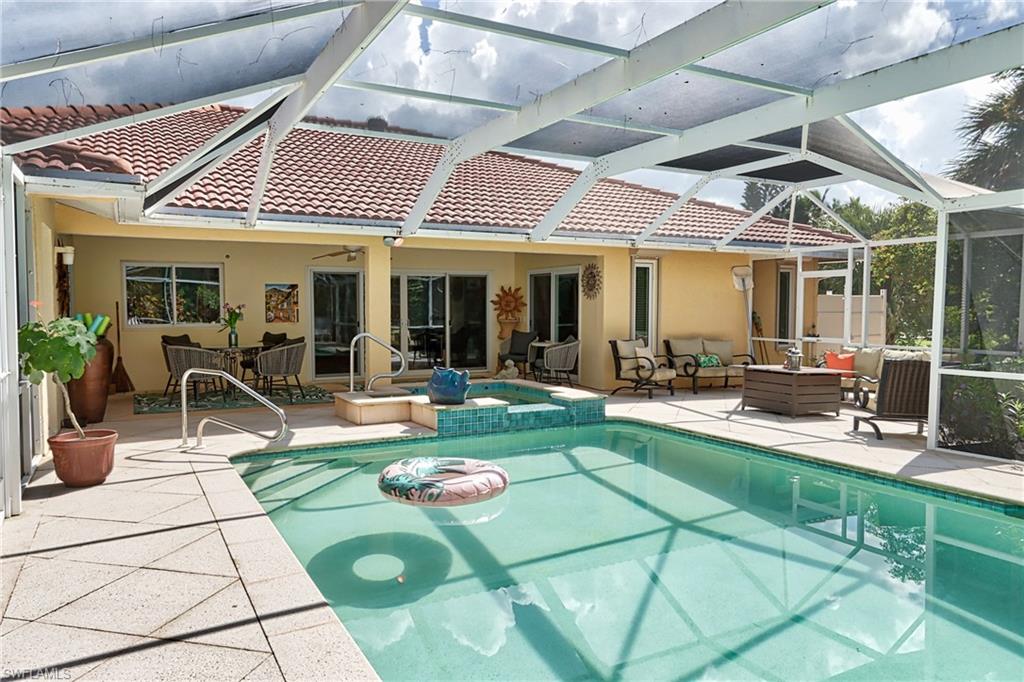 View of pool featuring a patio area, ceiling fan, an outdoor living space, an in ground hot tub, and a lanai