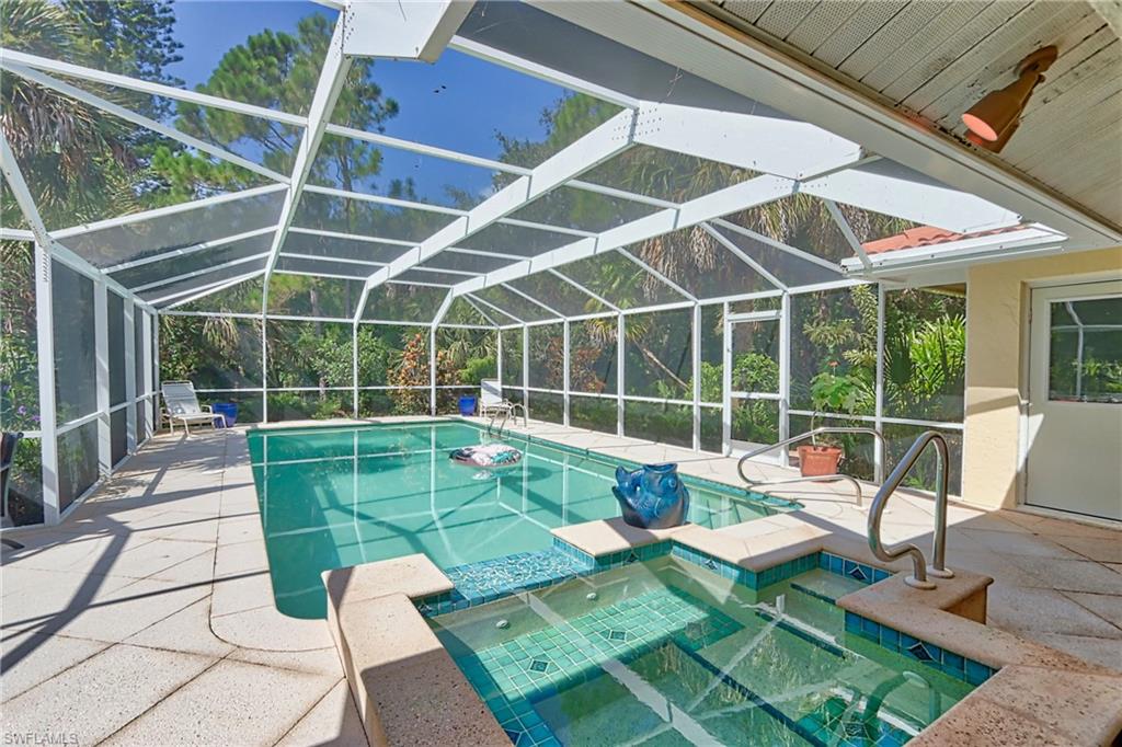 View of pool with a lanai, an in ground hot tub, and a patio area