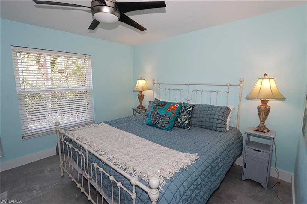 Bedroom featuring ceiling fan and dark tile floors
