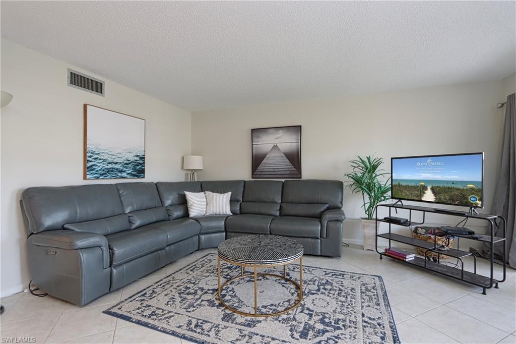 Living room with a textured ceiling and light tile floors