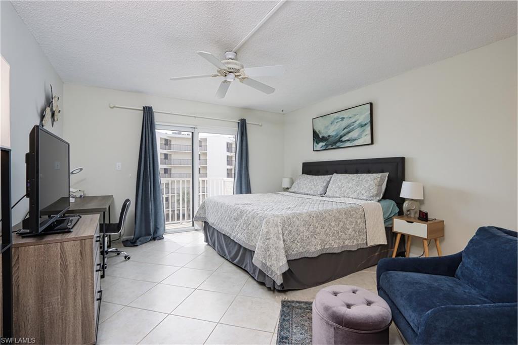 Bedroom with access to outside, a textured ceiling, ceiling fan, and light tile floors