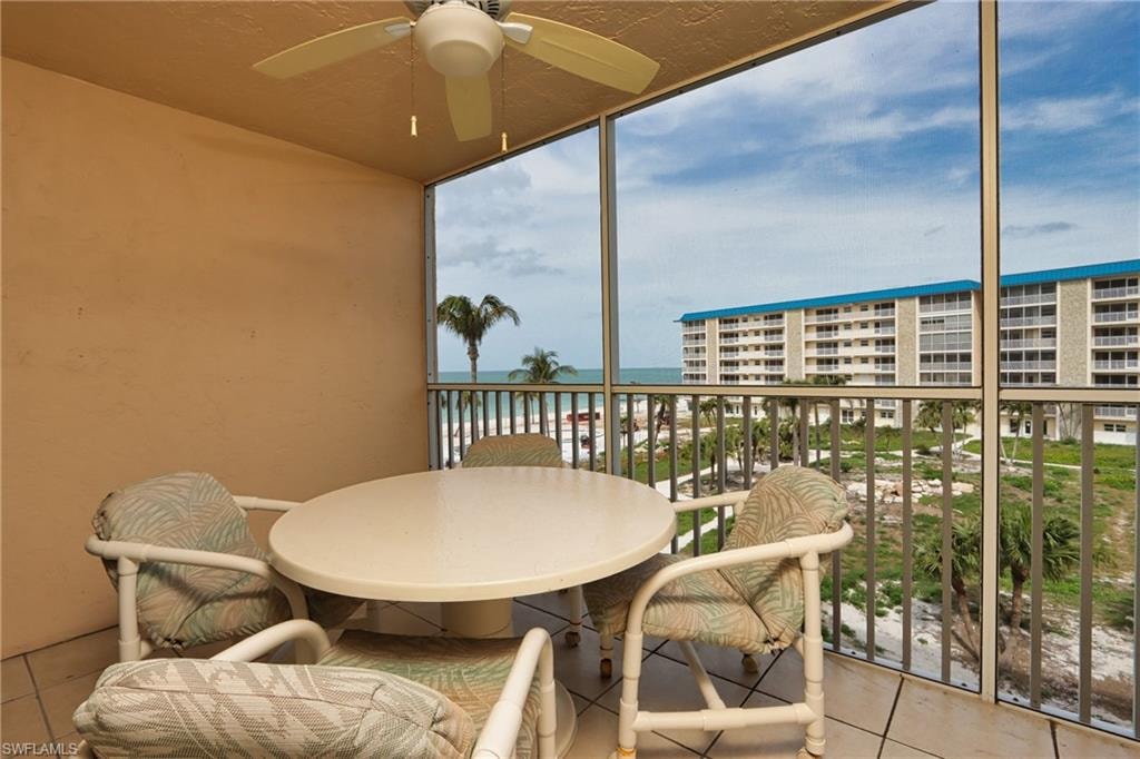 Balcony featuring a water view and ceiling fan