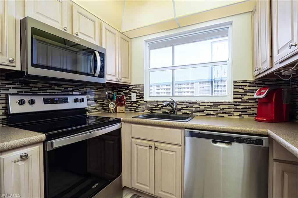 Kitchen featuring appliances with stainless steel finishes, sink, and tasteful backsplash