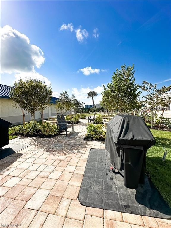 View of patio with a grill