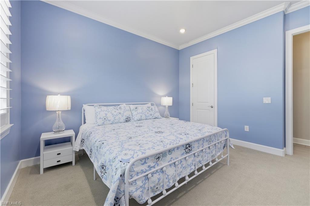 Bedroom with light carpet and crown molding