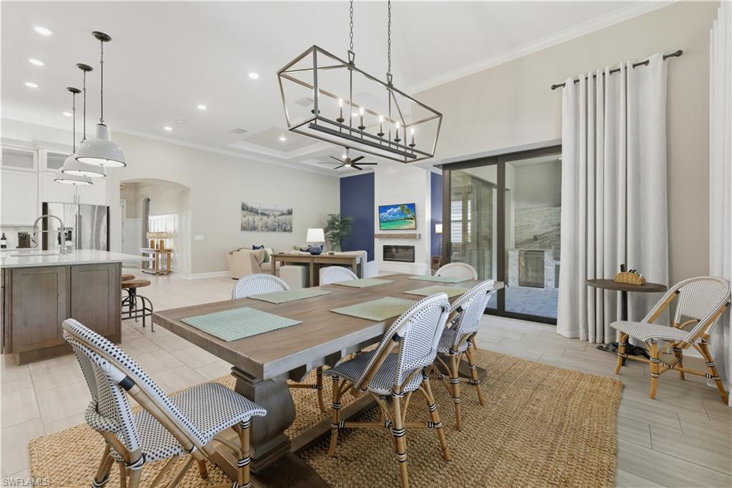 Dining area featuring ornamental molding, arched walkways, a chandelier, and recessed lighting