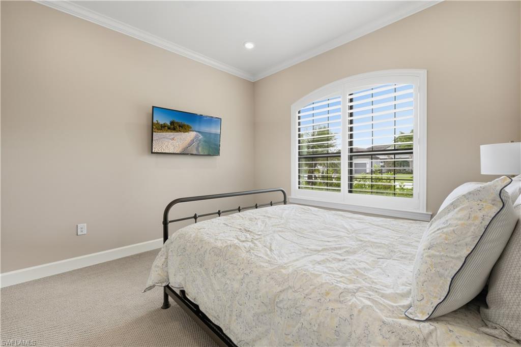 Carpeted bedroom featuring ornamental molding and baseboards