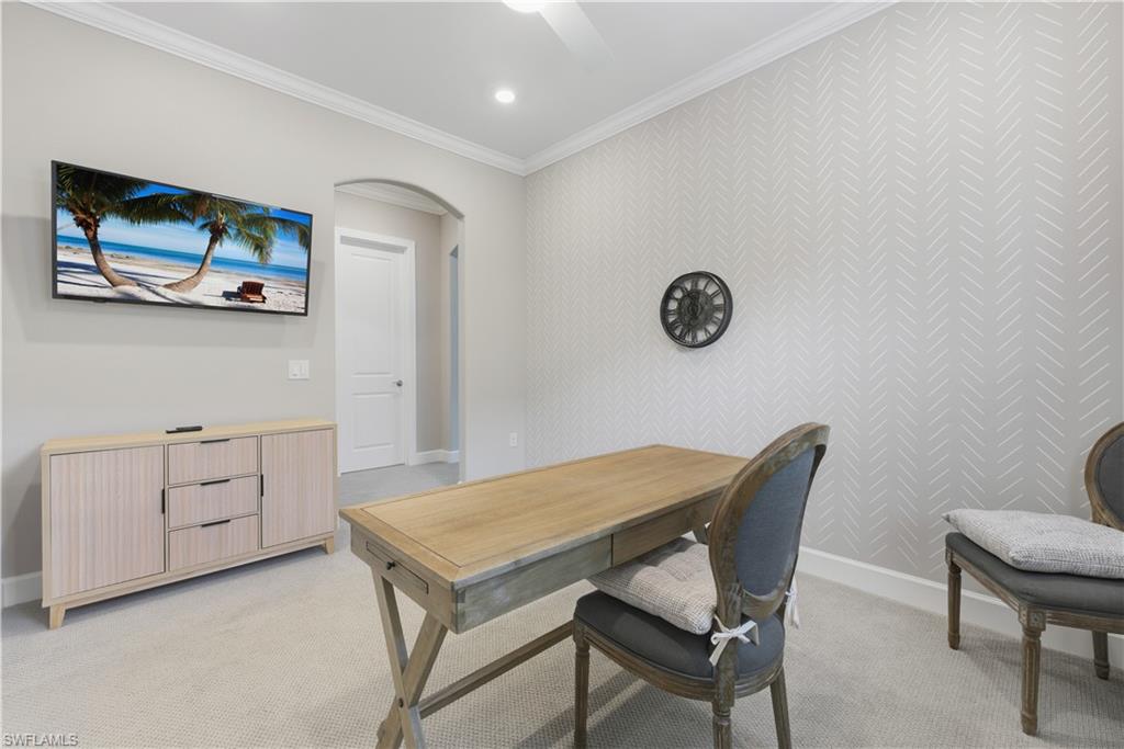 Office featuring arched walkways, ornamental molding, light carpet, recessed lighting, and an accent wall