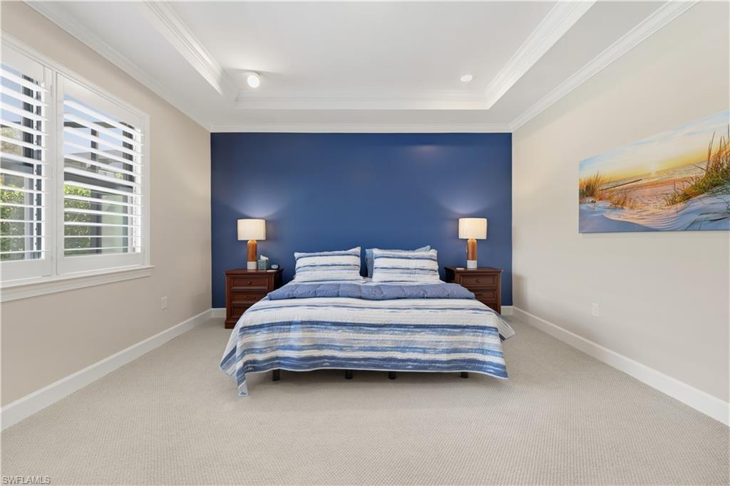 Bedroom with carpet flooring, crown molding, and a tray ceiling