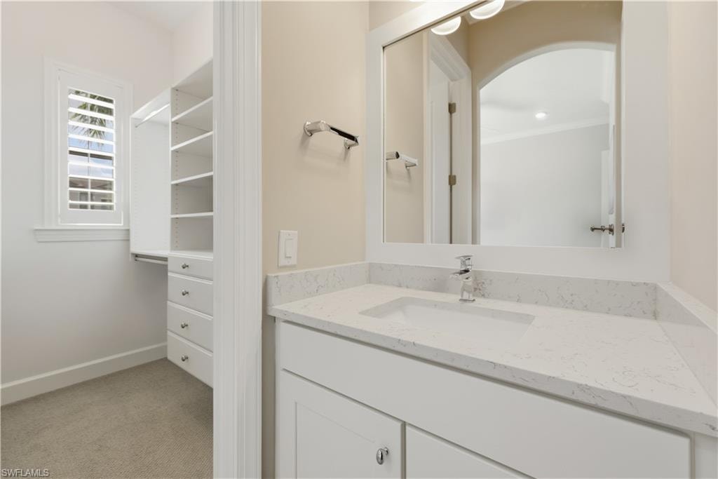 Bathroom with vanity and light carpet