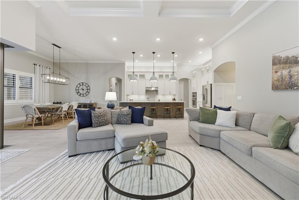 Living area with arched walkways, ornamental molding, recessed lighting, and a chandelier