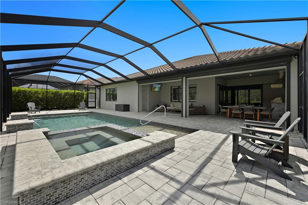 Rear view of property with a sunroom, a patio, a lanai, and stucco siding