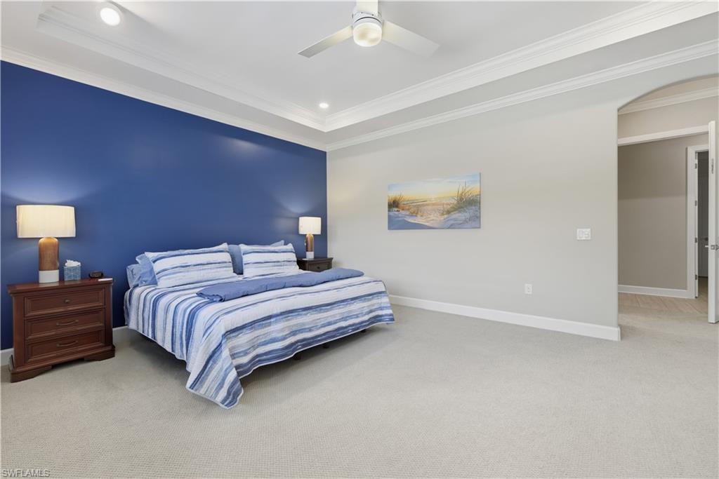 Carpeted bedroom with ornamental molding, ceiling fan, and recessed lighting