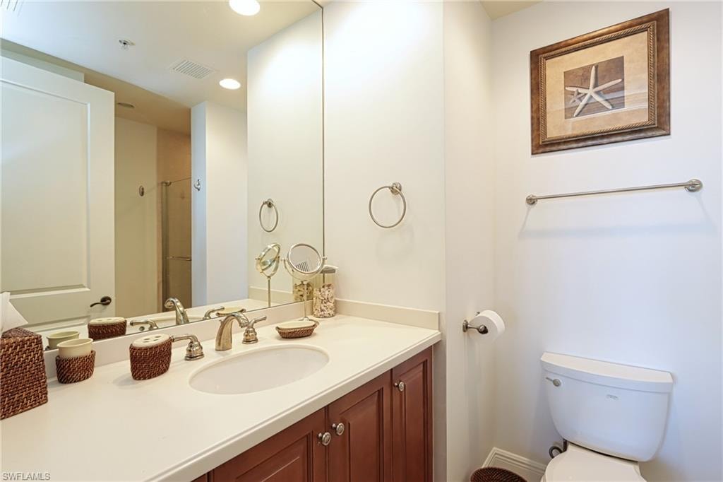 Bathroom with vanity, toilet, and walk in shower