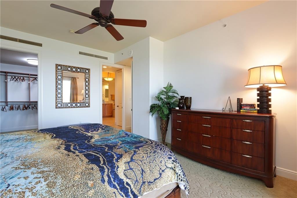 Bedroom with a closet, ceiling fan, ensuite bathroom, and a spacious closet