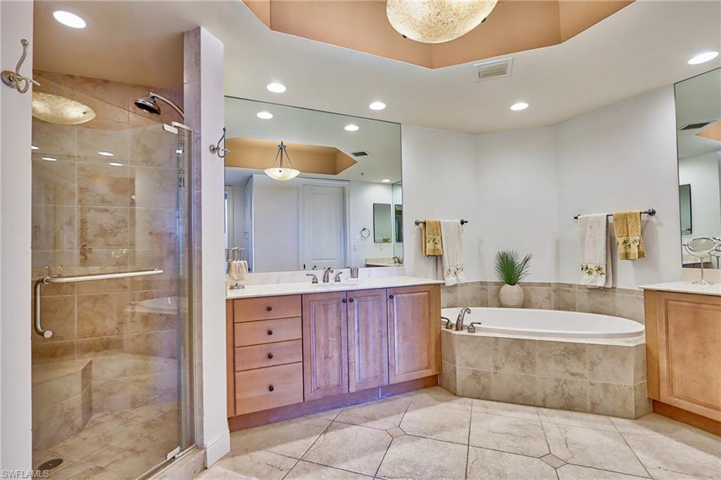 Bathroom featuring vanity, independent shower and bath, and tile patterned flooring