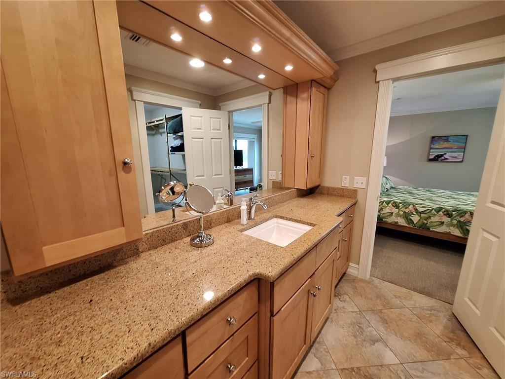 Bathroom featuring tile flooring, crown molding, and vanity
