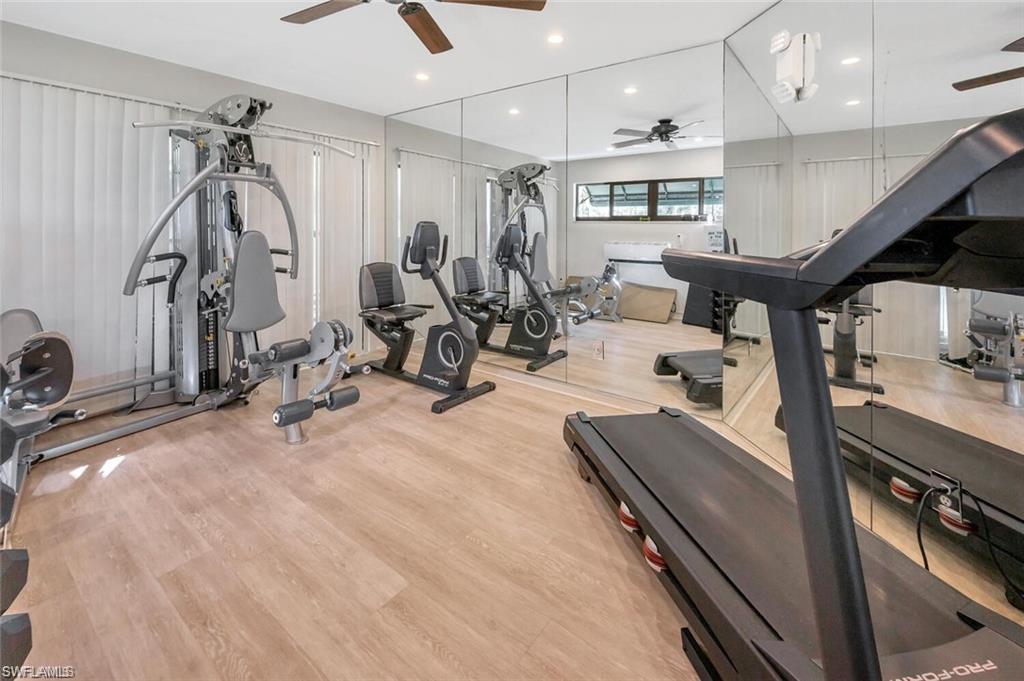 Workout area featuring ceiling fan and light wood-type flooring