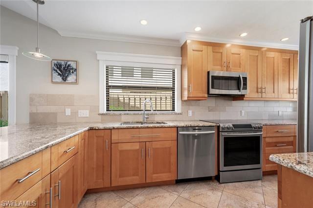 Upgraded Kitchen with stainless steel appliances, sink, tasteful backsplash, and light stone counters