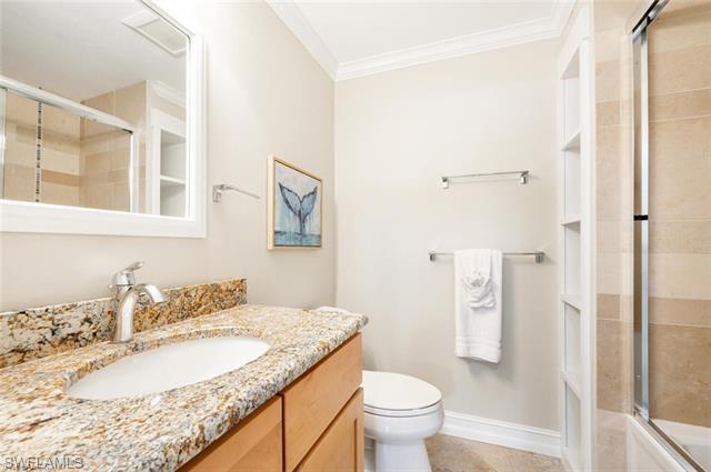 2nd Full bathroom featuring enclosed tub / shower combo, toilet, tile flooring, ornamental molding, and vanity