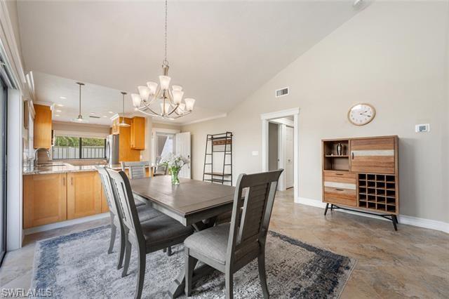 Side view of dining room with high vaulted ceiling and a chandelier