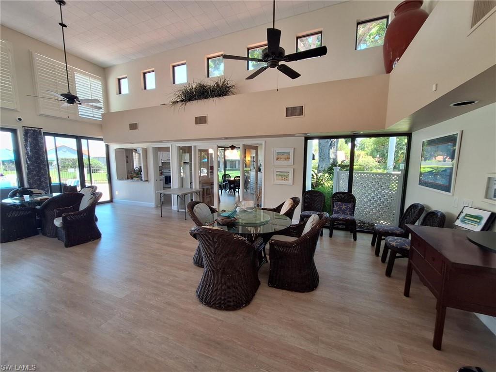 Community Lounge with a towering ceiling, hardwood / wood-style flooring, and ceiling fan