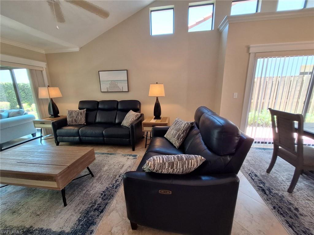 Living room with high vaulted ceiling, tile flooring, motorized loungers and ceiling fan