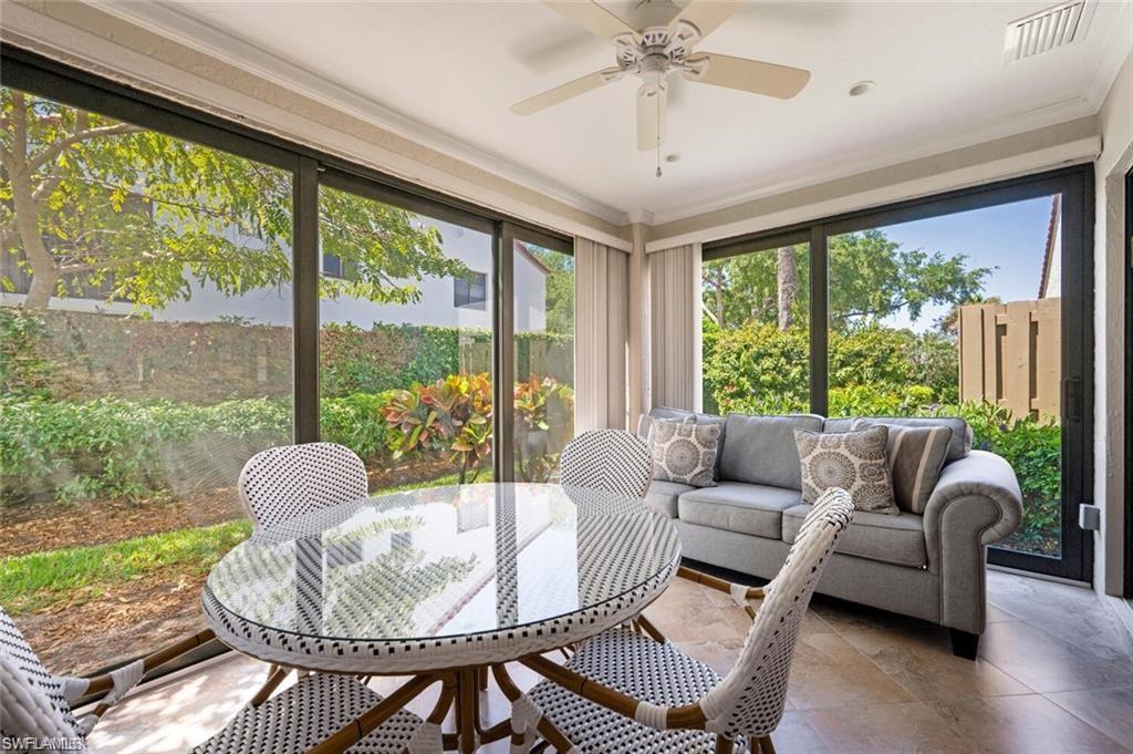 Sunroom with ceiling fan, dining table and sleeper sofa.