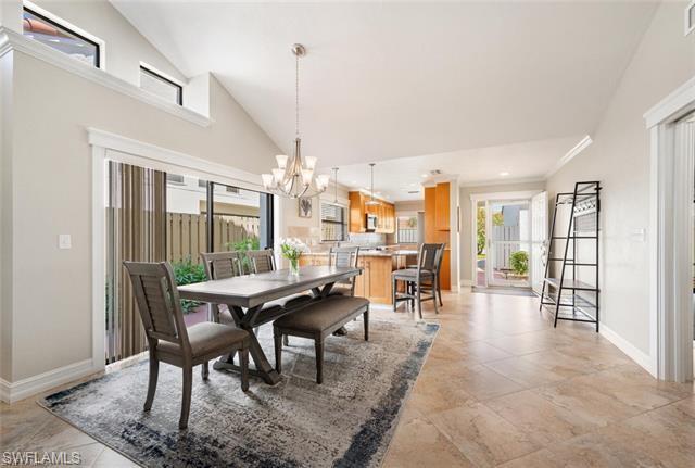 Tiled dining room with high vaulted ceiling and an inviting chandelier